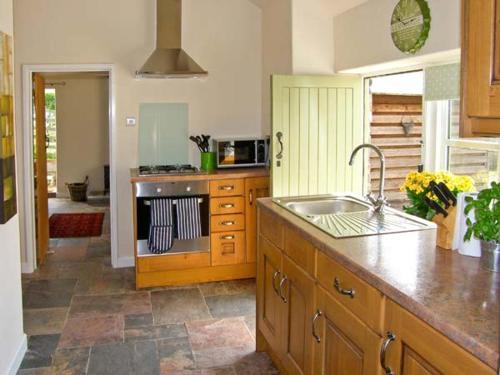 een keuken met een wastafel en een aanrecht bij Stone Cottage in Mold