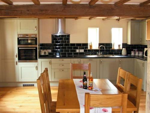 a kitchen with a wooden table with chairs and a tableablish at The Old Cider Mill in Farden