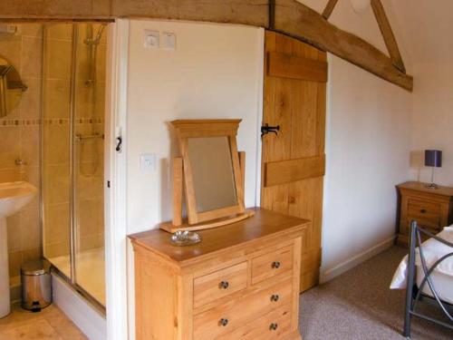 uma casa de banho com uma cómoda em madeira com um espelho. em The Old Cider Mill em Farden