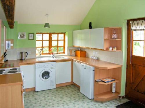 a kitchen with a washing machine and a washer at The Granary in Craven Arms