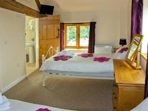 um quarto com uma cama grande com flores cor-de-rosa em The Old Cider Mill em Farden