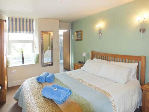 a bedroom with a large bed with blue towels on it at Swallows Nest in Coniston
