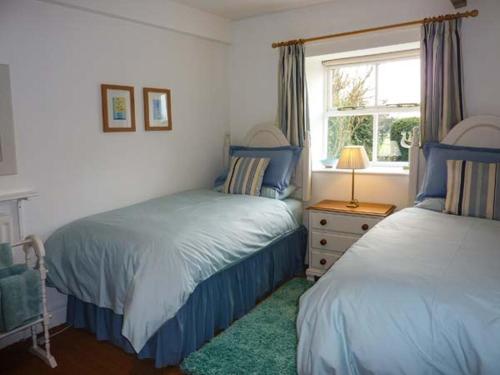 a bedroom with two beds and a window at Curlew Cottage in Barnard Castle