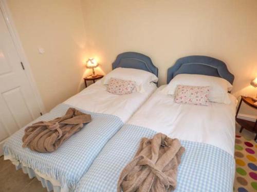 Dos camas en un dormitorio con toallas. en Stable Cottage en Stonegrave