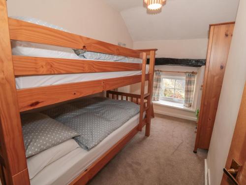 ein Schlafzimmer mit zwei Etagenbetten in einem Zimmer in der Unterkunft Daisy Cottage in Matlock