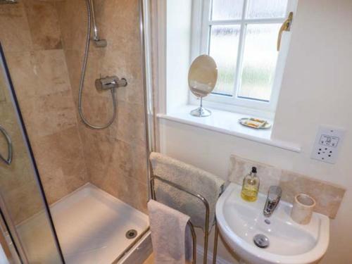 La salle de bains est pourvue d'une douche, d'un lavabo et de toilettes. dans l'établissement Stable Cottage, à Stonegrave