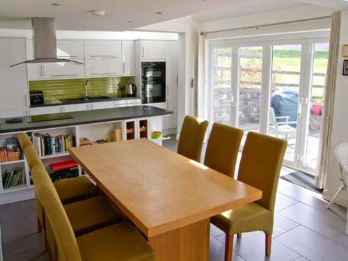 uma cozinha com uma mesa de madeira e cadeiras amarelas em Mountain View em Conwy