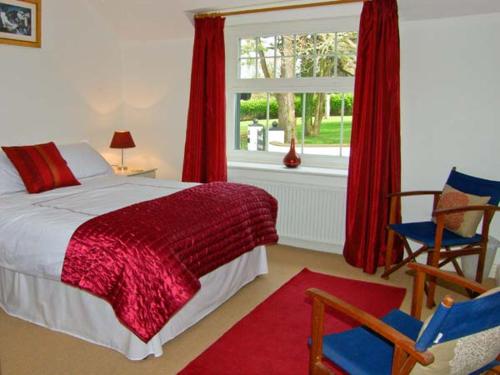 a bedroom with a bed and a window with red curtains at Mountain View in Conwy