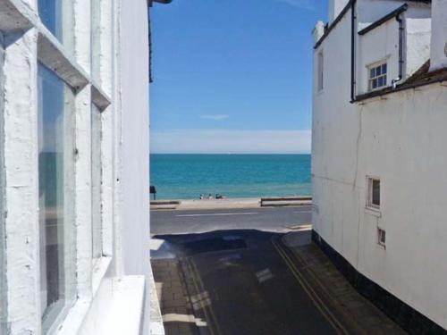 a view of the beach from a window of a building at Seashell Cottage in Deal