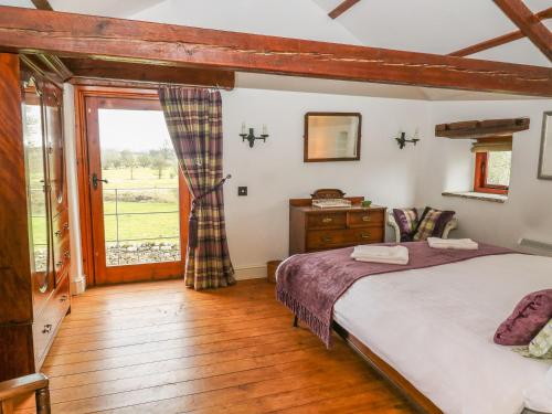 a bedroom with a large bed and a window at The Bothy in Leyburn