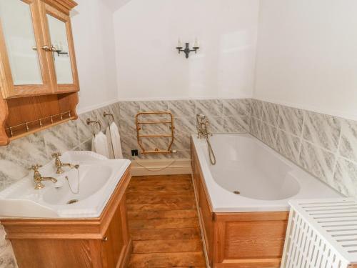 a bathroom with two sinks and a bath tub at The Bothy in Leyburn