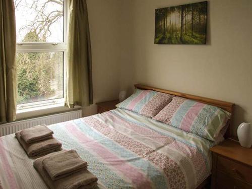 - une chambre avec un lit et des serviettes dans l'établissement Sunnyside, à Great Malvern