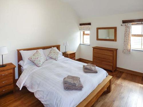sypialnia z dużym łóżkiem z dwoma ręcznikami w obiekcie Beudy w mieście Llangwm