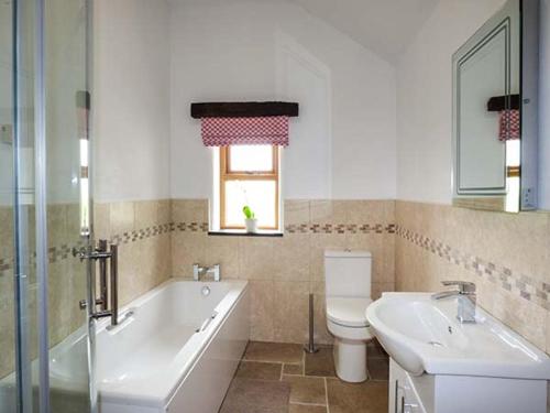 une salle de bain avec une baignoire, des toilettes et un lavabo dans l'établissement Beudy, à Llangwm