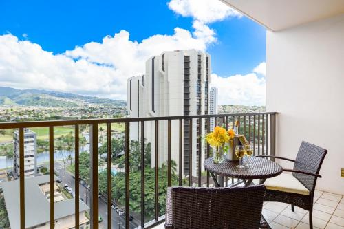 a balcony with a table and chairs and a view of a city at Mountain View Getaway, Free Parking and Beach Steps Away in Honolulu