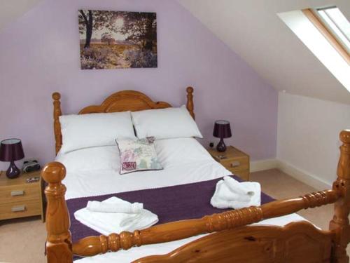 a bedroom with a wooden bed and two night stands at Mallard in Newnham