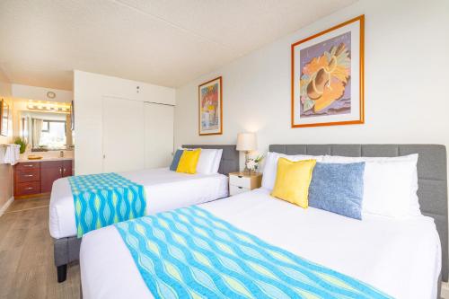a hotel room with two beds and a bathroom at Mountain View Getaway, Free Parking and Beach Steps Away in Honolulu