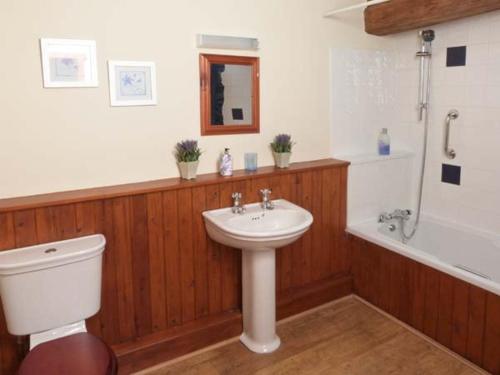 een badkamer met een wastafel, een toilet en een bad bij The Byre in Grange Over Sands