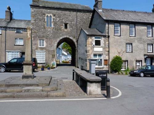 un antiguo edificio de piedra con un arco en una calle en The Byre, en Grange-over-Sands