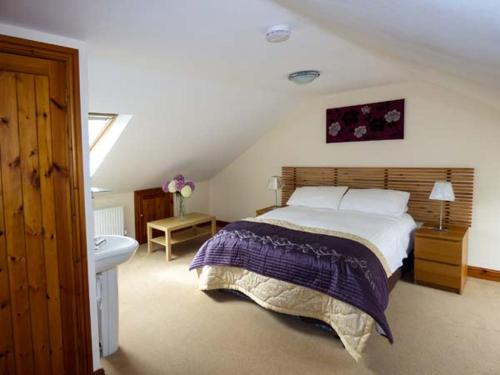 a bedroom with a large bed and a sink at Poppy Cottage in Lancaster