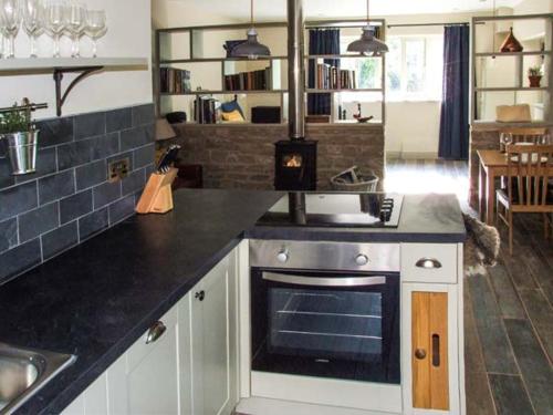 a kitchen with a stove and a counter top at The Stable in Ross on Wye