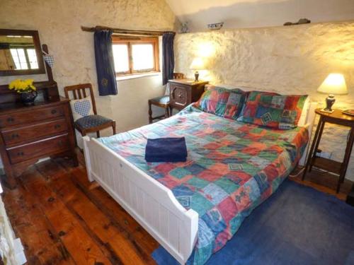ein Schlafzimmer mit einem großen Bett mit einer bunten Bettdecke in der Unterkunft The Mill in Bicknoller
