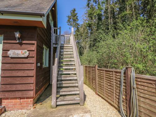 a wooden staircase leading to a house with a fence at The Roost in Broughton