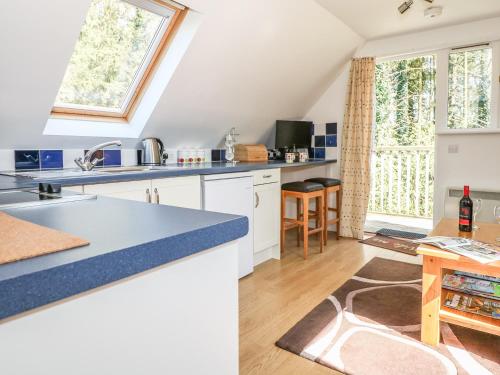 a kitchen with white cabinets and a large window at The Roost in Broughton