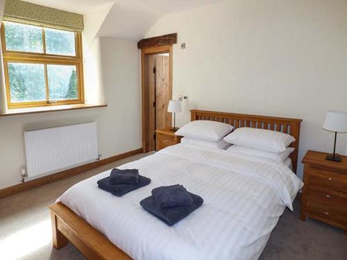 LlangwmにあるTy Gwynのベッドルーム1室(大きな白いベッド1台、タオル付)