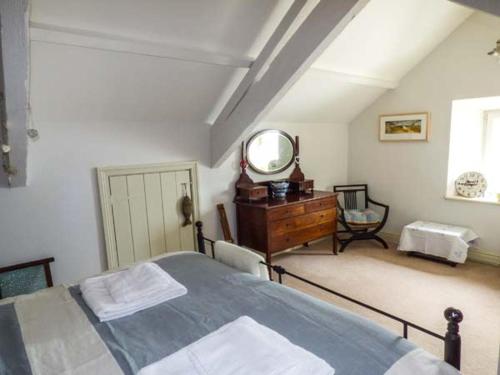 a bedroom with a bed and a mirror and a dresser at Rose Cottage in Cardigan