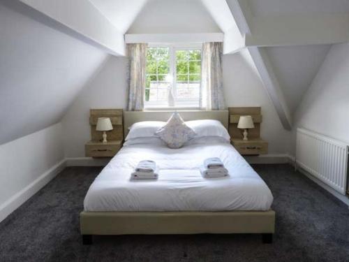 a bedroom with a large white bed with two lamps at The Nook in Windermere