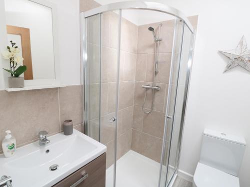 a bathroom with a shower and a sink at Bramble Cottage in Holmfirth