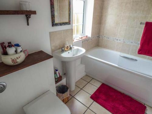 a bathroom with a white tub and a sink at The Old Smithy in Bridport