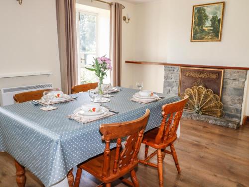 uma mesa de jantar com cadeiras e uma toalha de mesa azul em Marsh Cottage em South Molton