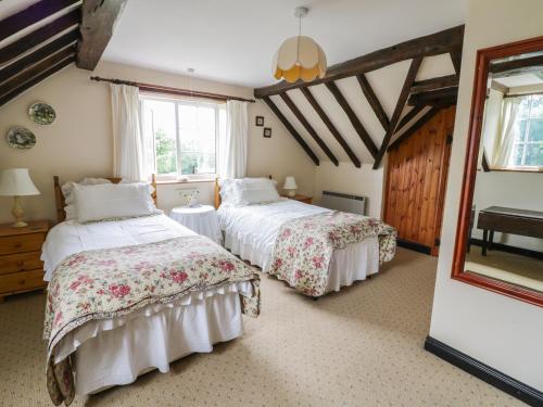 a bedroom with two beds and a window at White Cottage in Hopton Wafers