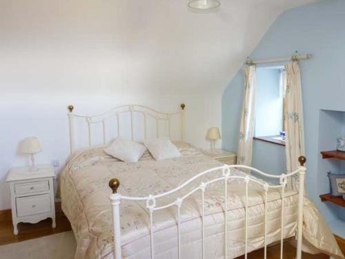 a bedroom with a white bed and a window at Annie's Cottage in Clogher