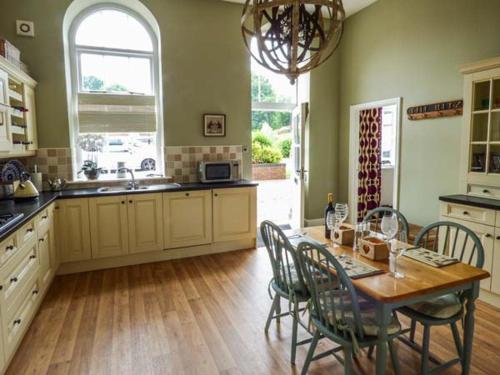 a kitchen with a wooden table and chairs and a dining room at The School House in Cockermouth