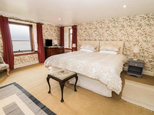 um quarto com uma cama grande e papel de parede floral em The Lookout em Tweedmouth