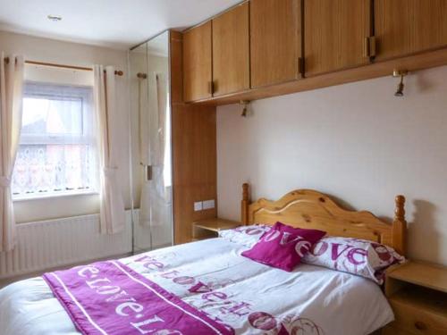 um quarto com uma cama com uma cabeceira de madeira em High Tide em Belmullet
