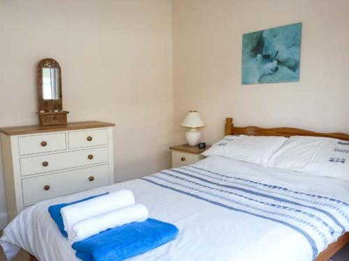 a bedroom with a bed with towels on it at Sunshine Cottage in Teignmouth