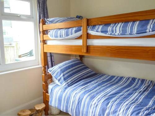 a bedroom with two bunk beds and a window at Sunshine Cottage in Teignmouth