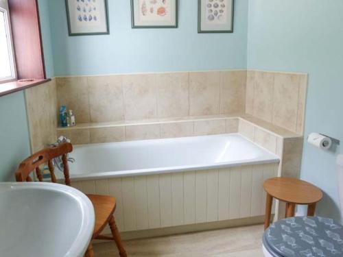 a bathroom with a tub and a table and a sink at Fisherman's Cottage in Ullapool