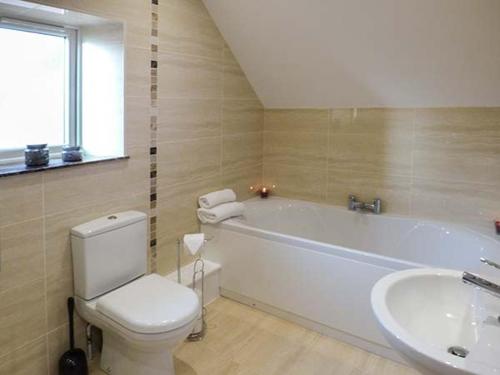ein Badezimmer mit einer weißen Badewanne, einem WC und einem Waschbecken in der Unterkunft Rose Cottage in Winforton