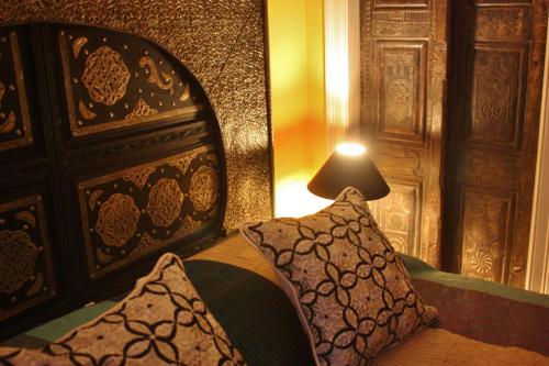 a bedroom with a bed with a pillow and a lamp at Moroccan Boutique Guest House in Boston
