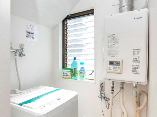 een wasruimte met een wasmachine en een raam bij Kiba no Tsuru Carane Hotel - Vacation STAY 09997v in Tokyo