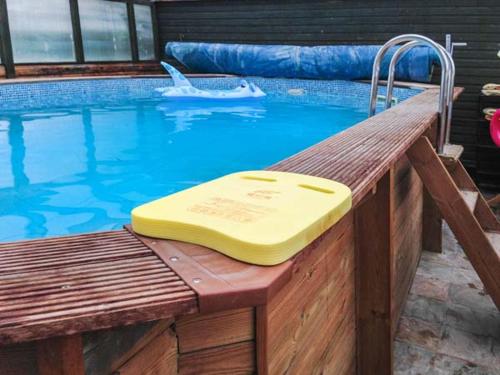 a yellow tray sitting on a wooden bench next to a swimming pool at The Willows in Ellesmere