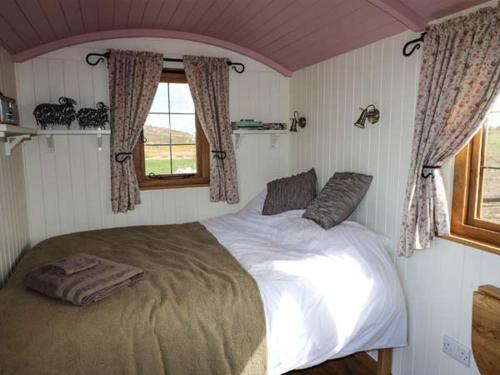 a bedroom with a large bed with a window at Llety'r Bugail in Holyhead