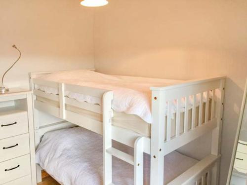 a bedroom with a white bunk bed and a desk at Croft Cottage in Pateley Bridge