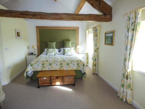 een slaapkamer met een groot bed en een tafel bij Kestrel Cottage in Grange Over Sands