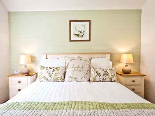 a bedroom with a white bed with pillows and two lamps at Ash Lodge in Ulverston